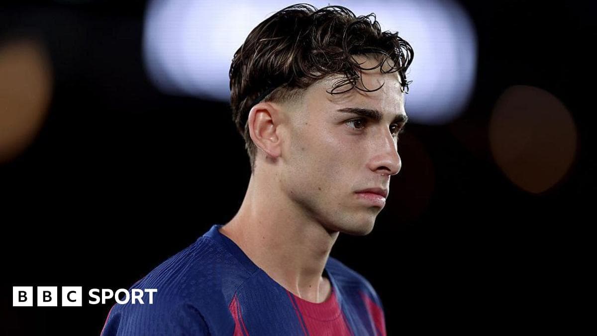 Jugador de fútbol en uniforme de Barcelona mirando pensativo