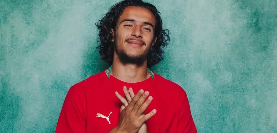 Jugador posando con camiseta roja en fondo azul