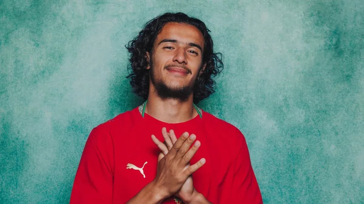 Jugador posando con camiseta roja en fondo azul