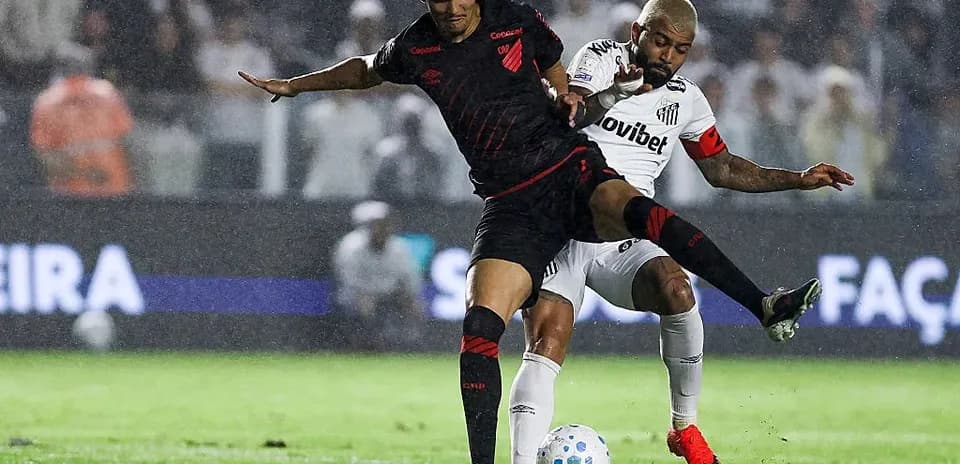 Jugador de Athletico Paranaense defendiendo ante jugador de Santos