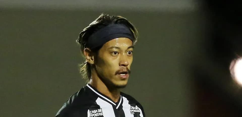 Jugador con camiseta negra y blanca en campo de fútbol