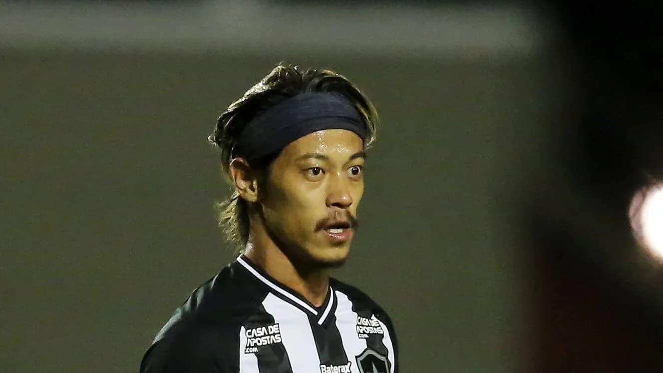 Jugador con camiseta negra y blanca en campo de fútbol