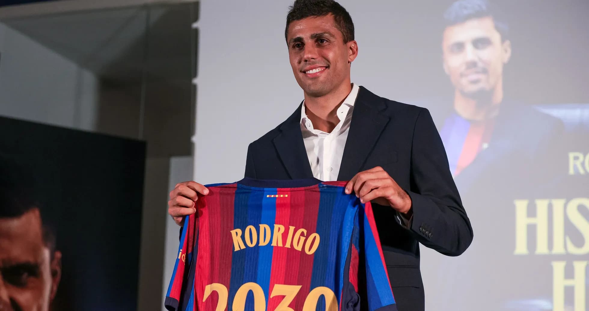 Jugador sosteniendo camiseta de Barcelona con nombre Rodrigo