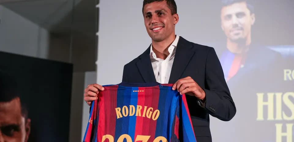 Jugador sosteniendo camiseta de Barcelona con nombre Rodrigo
