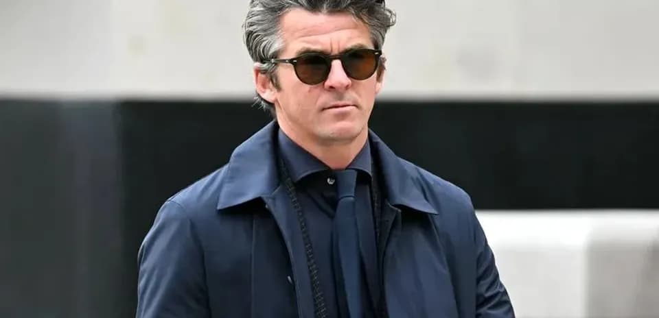 Hombre con gafas de sol caminando con chaqueta azul