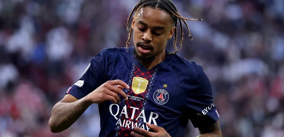 Jugador de PSG tocando el escudo en su camiseta