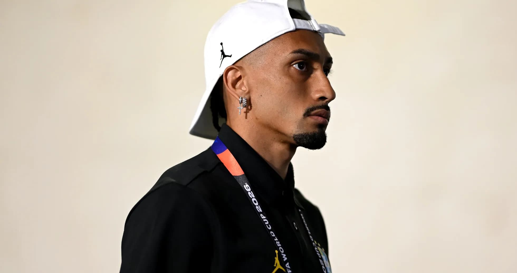 Jugador entrando al estadio con gorra blanca