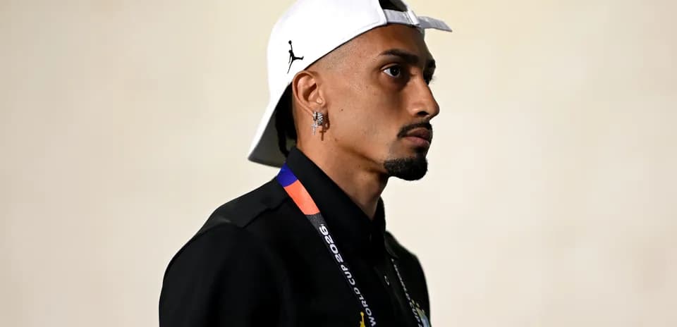 Jugador entrando al estadio con gorra blanca