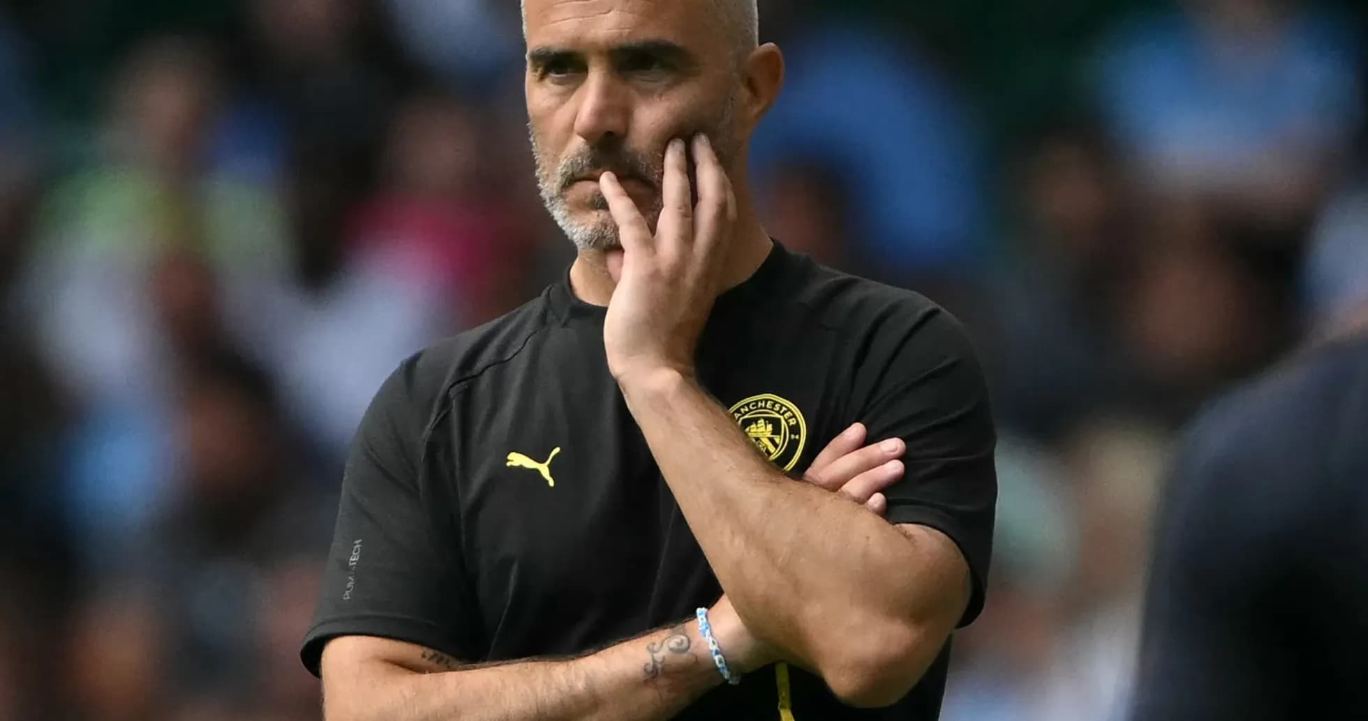 Entrenador observando el partido con expresión pensativa