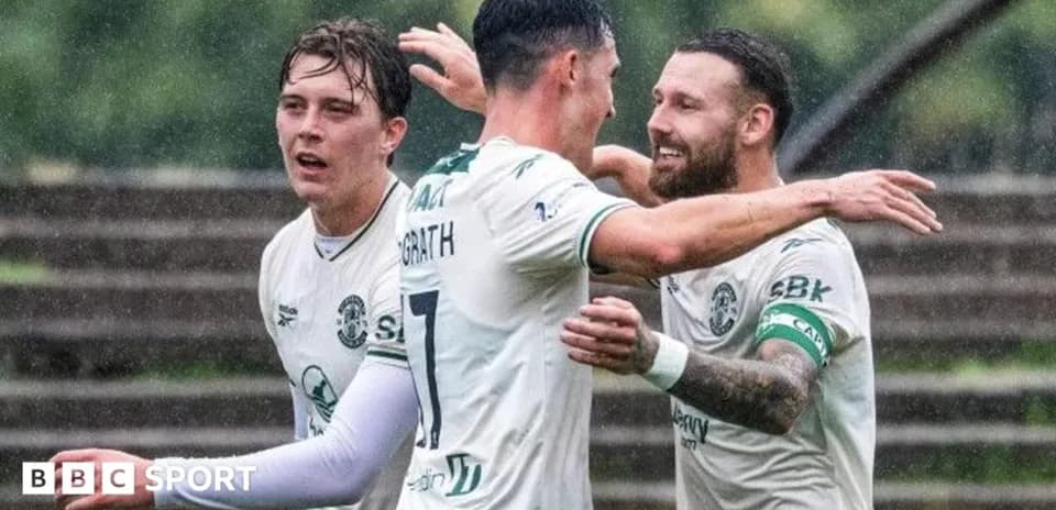 Jugadores de Hibernian celebrando un gol en la lluvia