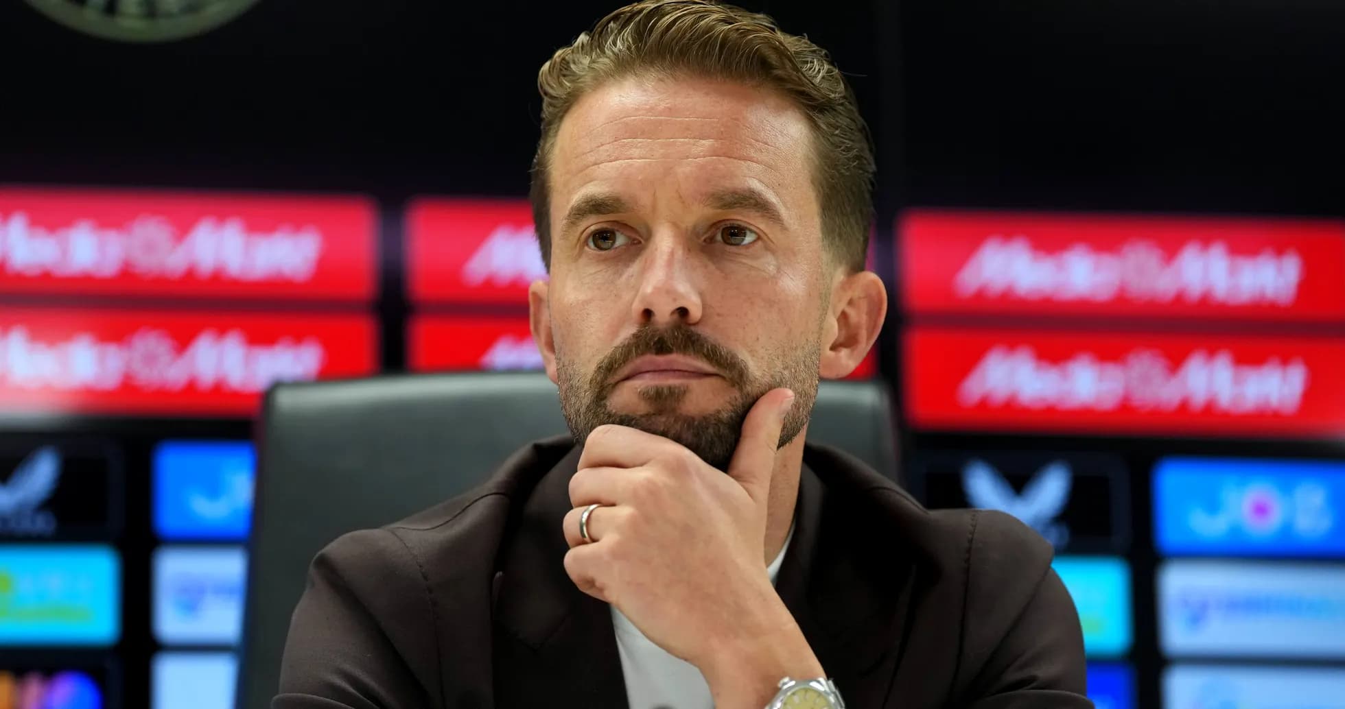 Entrenador reflexionando en conferencia de prensa