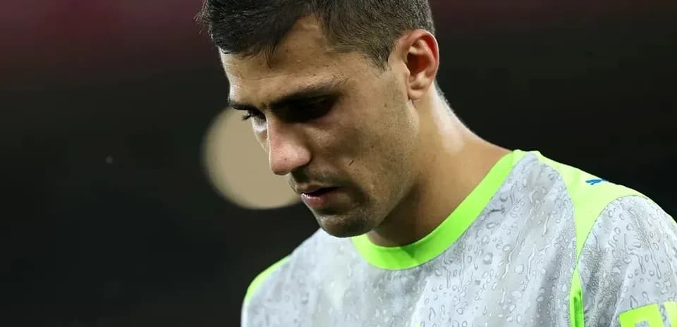 Jugador con uniforme de calentamiento, mirando hacia abajo
