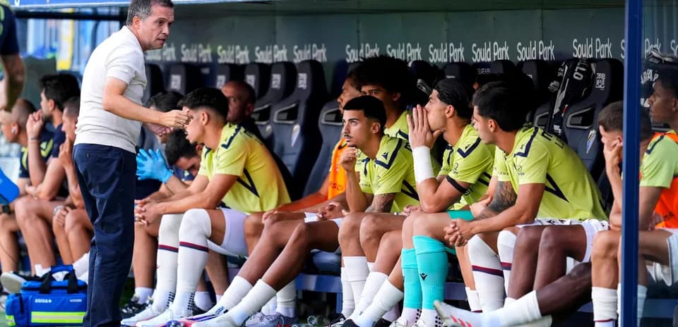 Entrenador dando instrucciones a jugadores en el banquillo