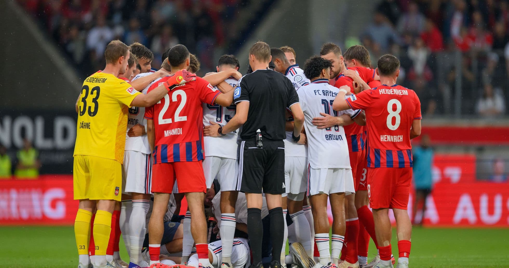 Jugadores de ambos equipos en un abrazo grupal