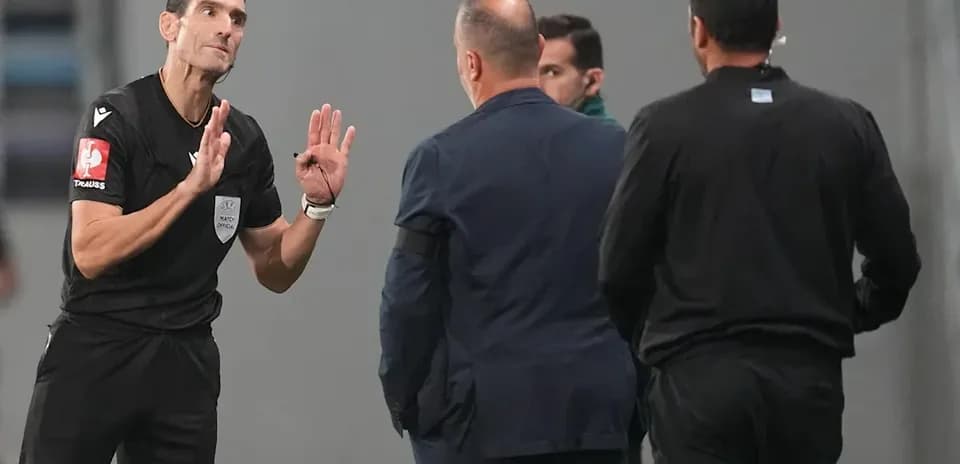 Árbitro hablando con entrenadores en la línea de banda
