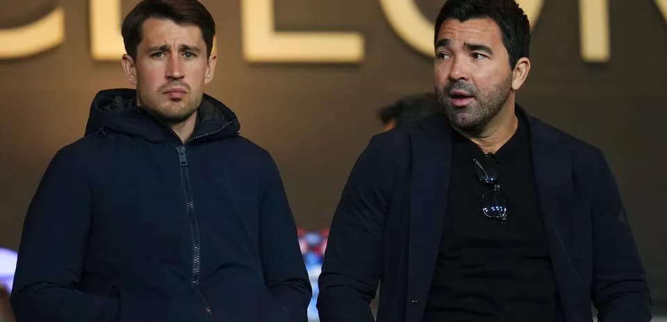 Dos hombres sentados en un palco de estadio