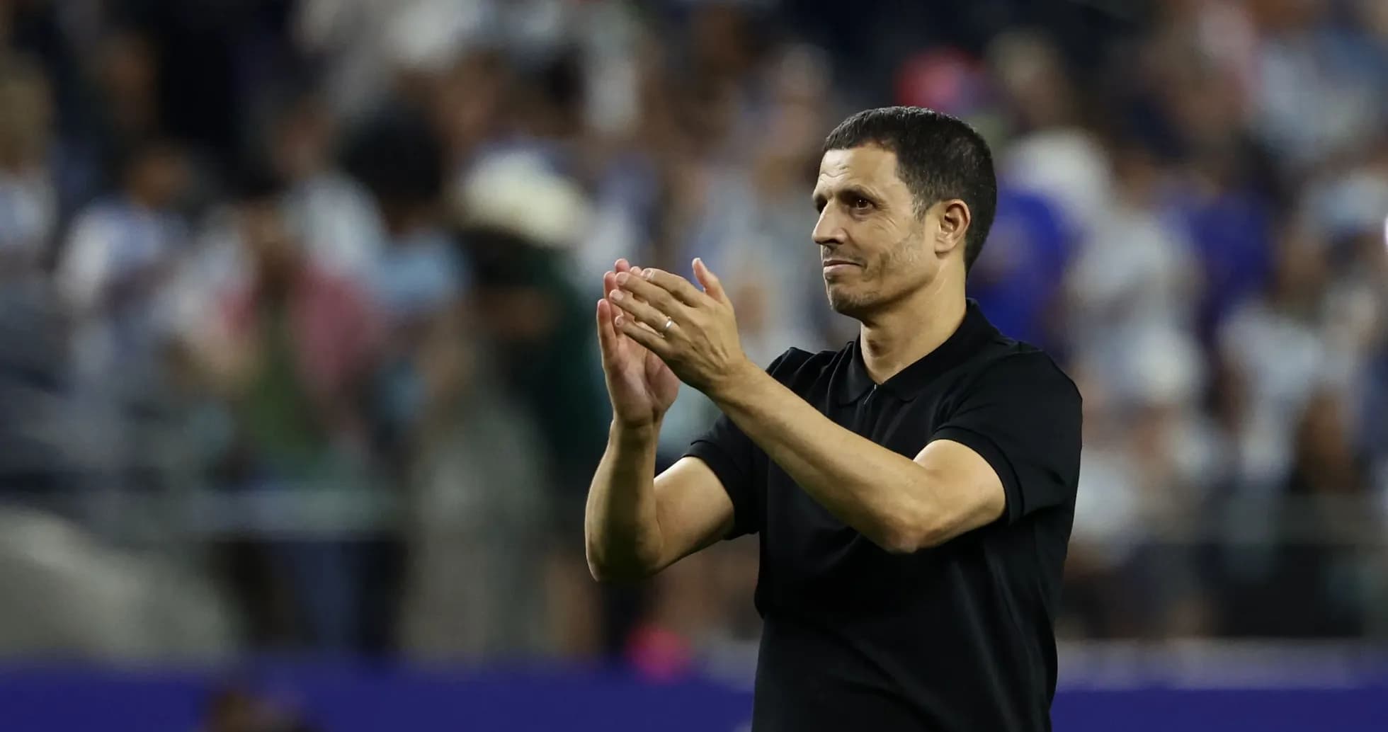 Entrenador aplaudiendo a la afición en el estadio