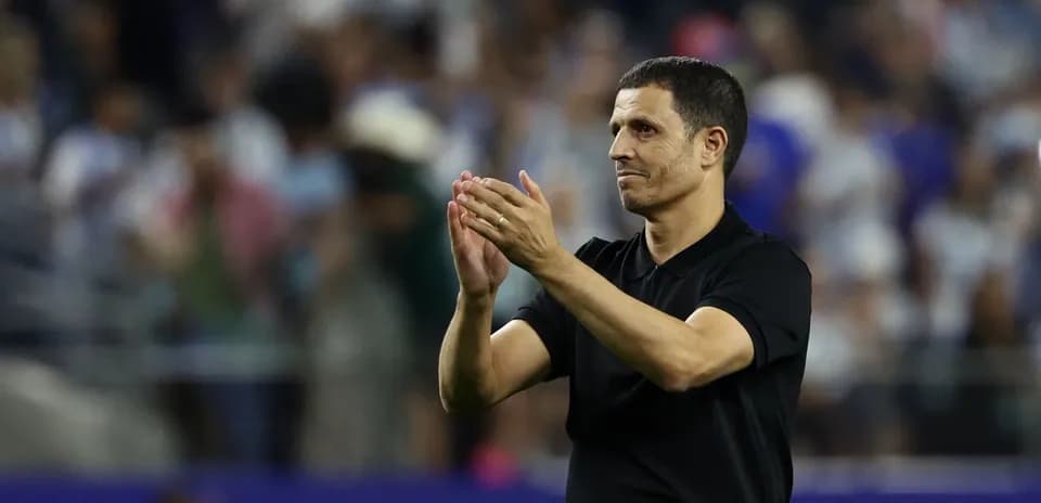 Entrenador aplaudiendo a la afición en el estadio