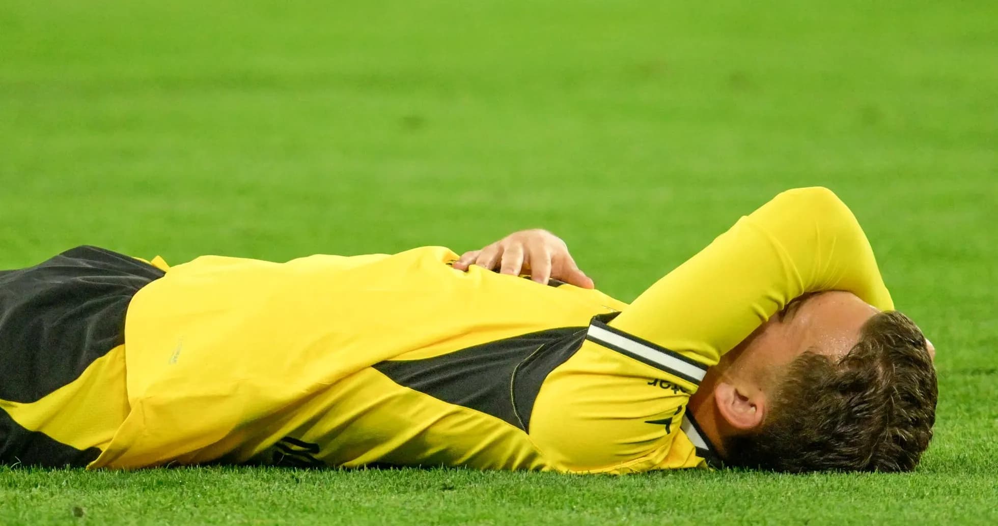 Jugador en el suelo con la cabeza cubierta