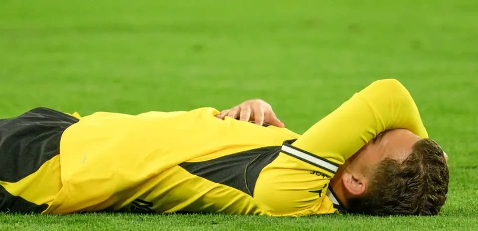 Jugador en el suelo con la cabeza cubierta