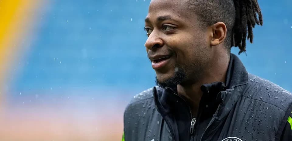 Jugador sonriente con chaqueta de entrenamiento en lluvia