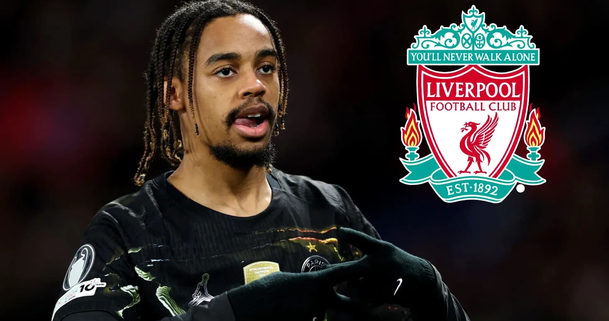 Jugador señalando el escudo de Liverpool en el campo