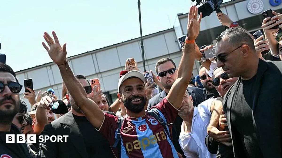 Jugador saludando a aficionados en el aeropuerto
