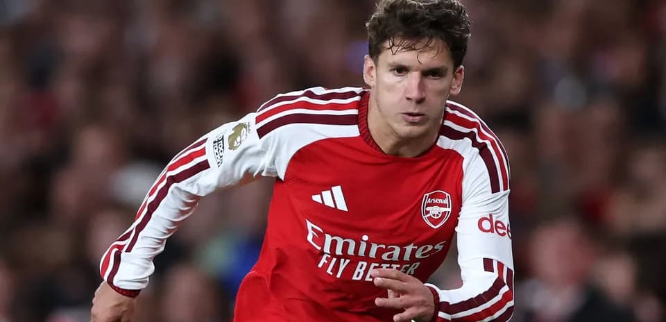 Jugador de Arsenal corriendo con balón en el campo