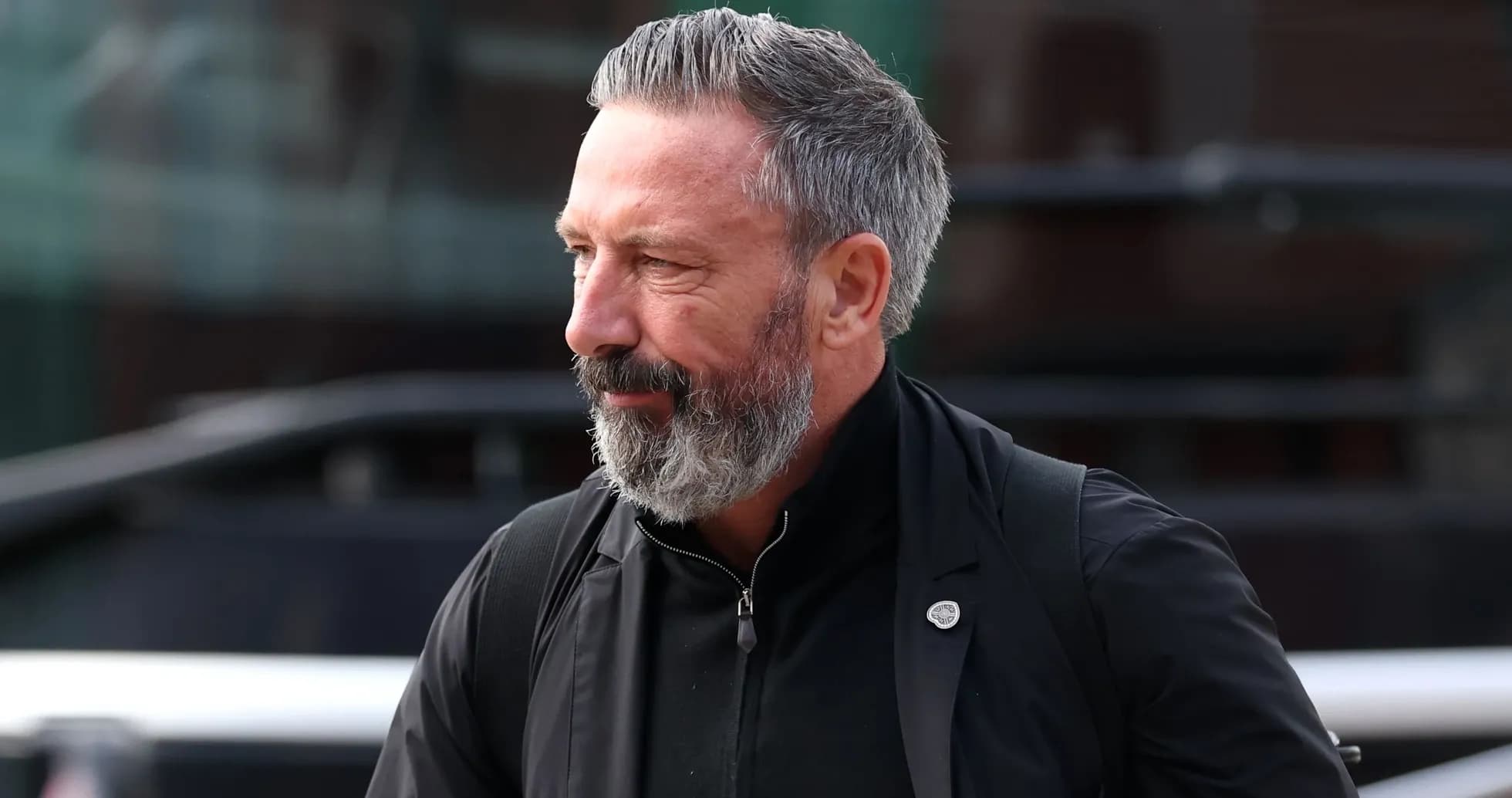 Hombre con barba gris caminando hacia un lugar