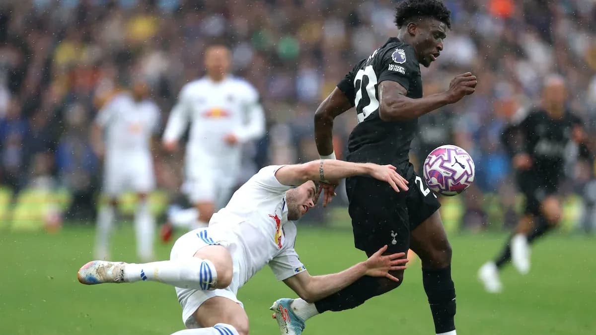 Jugador de Tottenham corriendo mientras otro cae al suelo