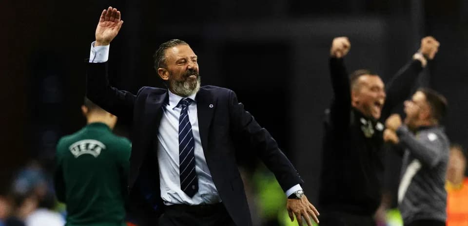 Entrenador celebrando con los brazos levantados