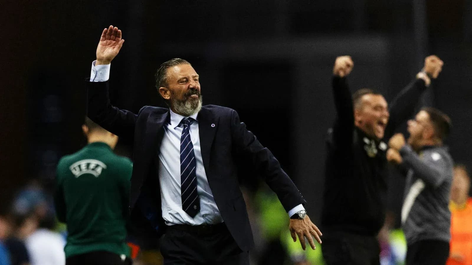 Entrenador celebrando con los brazos levantados