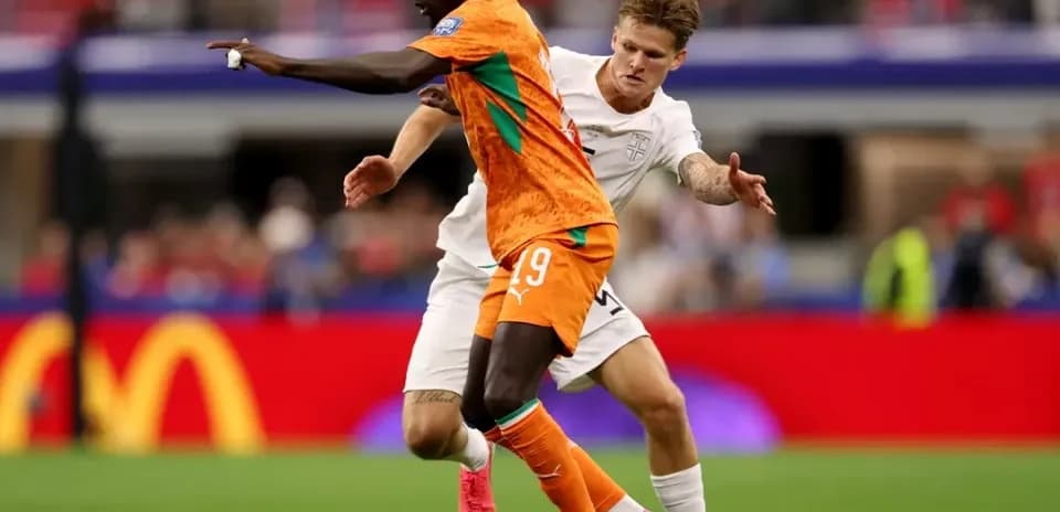 Jugador de Costa de Marfil driblando ante oponente inglés