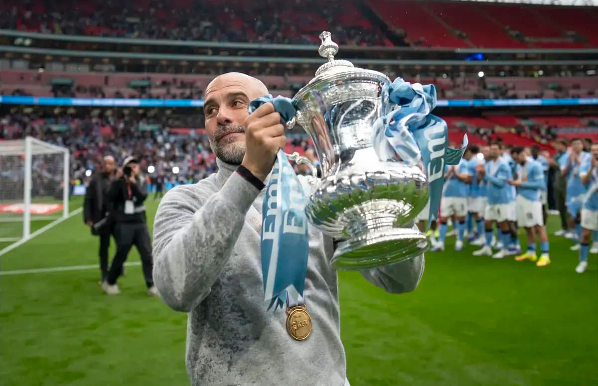 Entrenador sosteniendo el trofeo en Wembley
