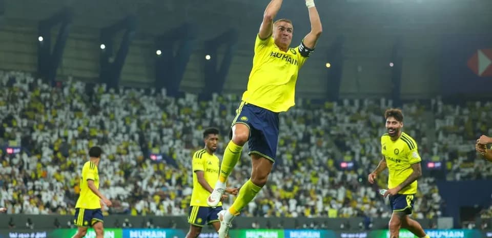 Jugador saltando en celebración con compañeros de equipo