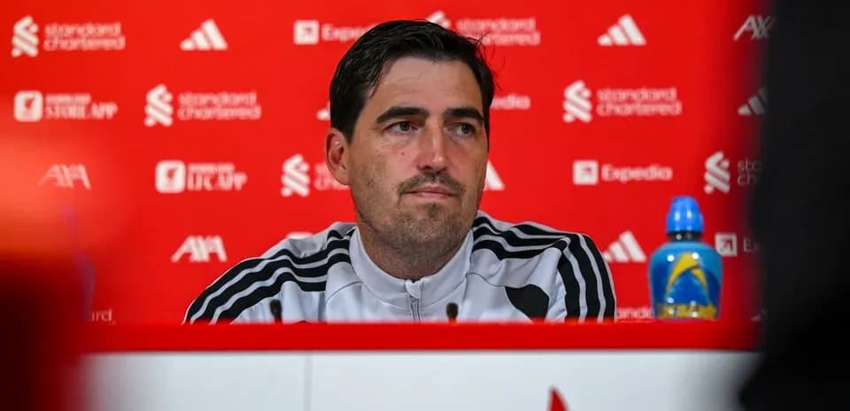 Entrenador en rueda de prensa con fondo rojo