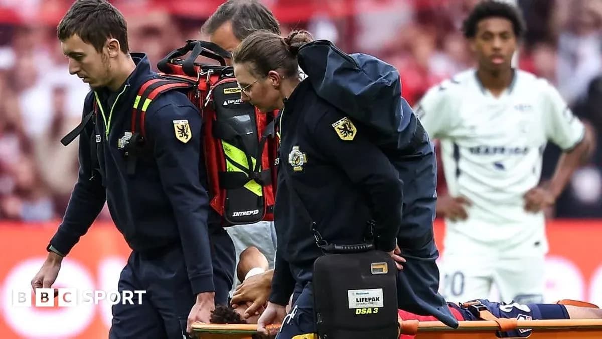 Equipo médico transportando a jugador herido en camilla