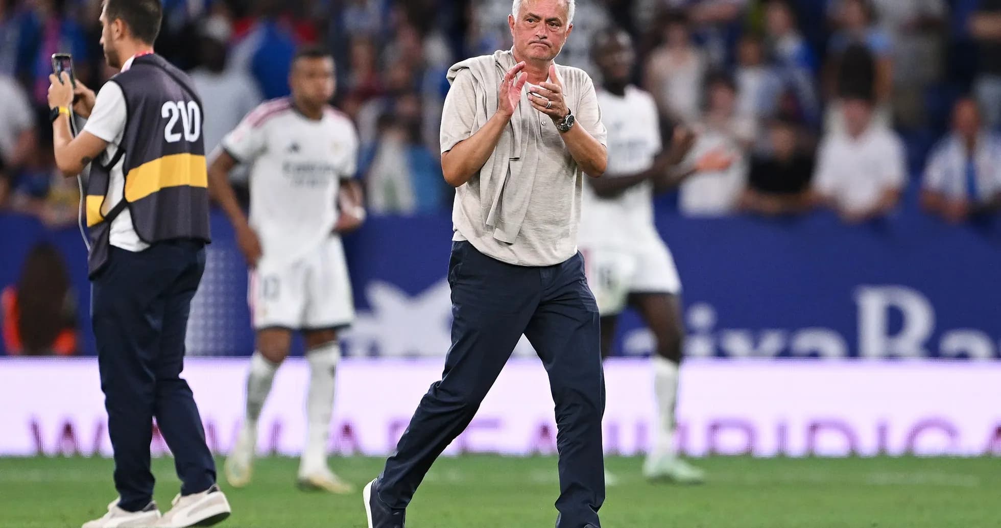 Entrenador aplaudiendo en el campo durante el partido