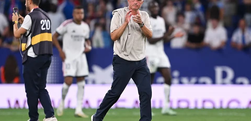 Entrenador aplaudiendo en el campo durante el partido