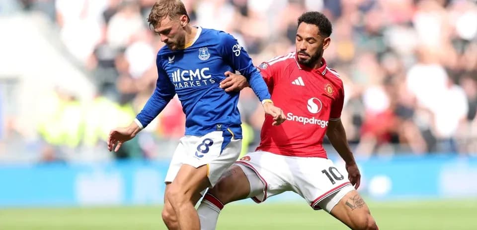 Jugador de Everton driblando mientras es presionado por Manchester United