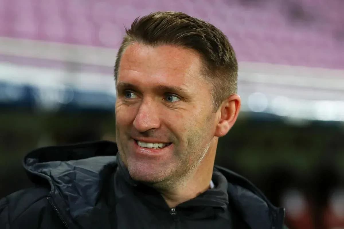 Entrenador sonriendo durante la previa del partido