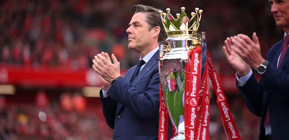 Hombre aplaudiendo junto al trofeo de Premier League