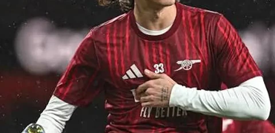 Jugador de Arsenal ajustando su uniforme en el campo