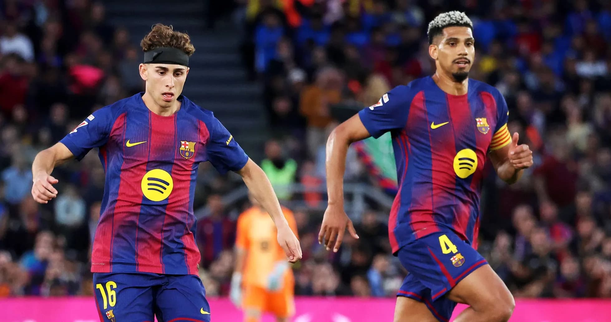 Dos jugadores del FC Barcelona corriendo en el campo