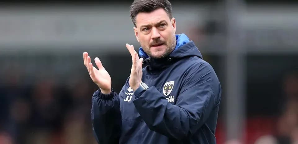 Entrenador aplaudiendo durante un partido de fútbol