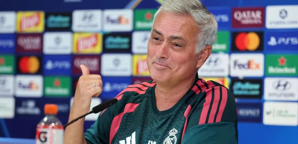 Entrenador en conferencia de prensa con logotipos de patrocinadores