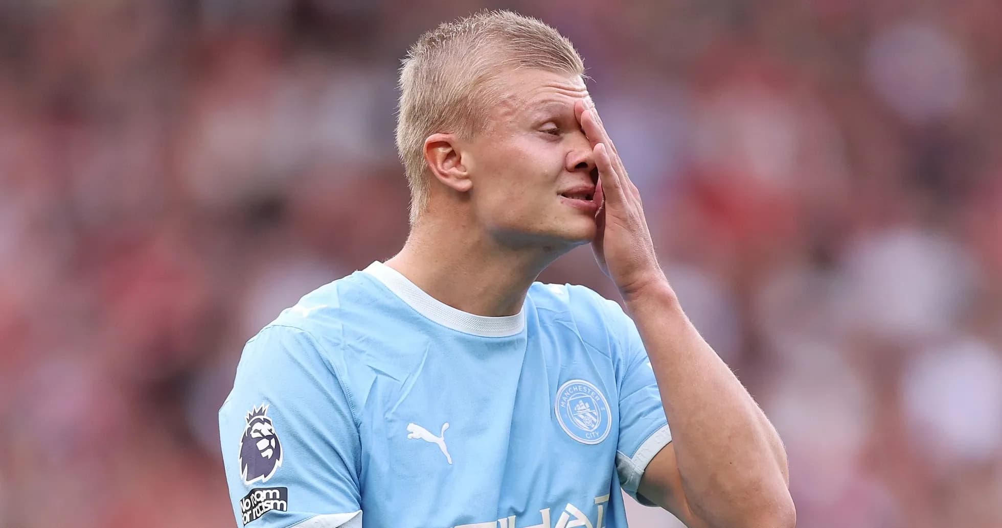 Jugador de Manchester City tocándose la cara en el campo