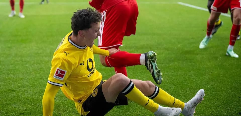 Jugador de Borussia Dortmund cayendo al suelo en partido