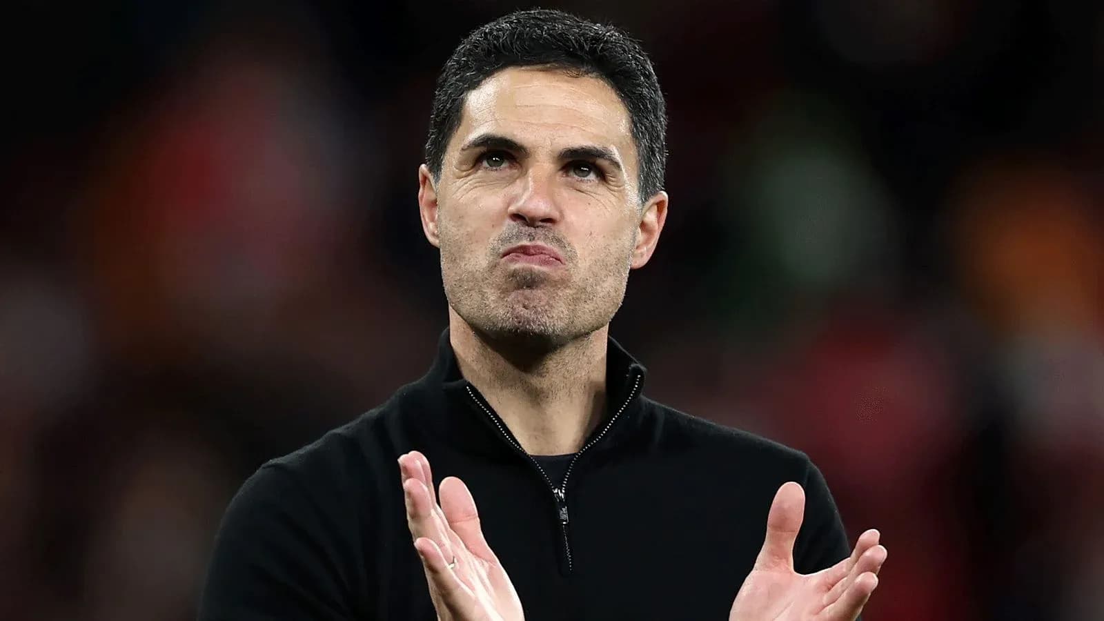 Entrenador aplaudiendo en el estadio durante partido