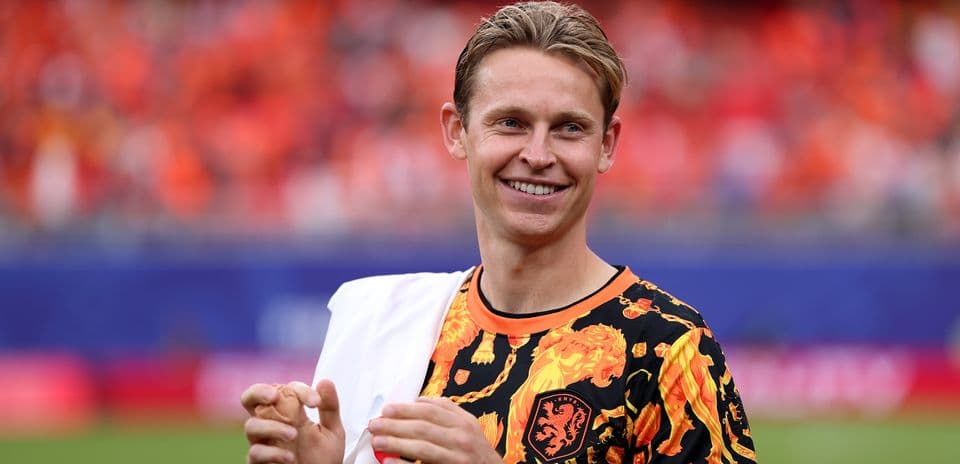 Jugador con camiseta naranja en el campo de fútbol